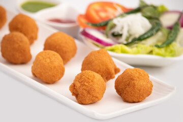 Indian Delhi Street Chaat Food Ram Laddu Pakode Or Raam Ladoo Pakore Is Made Of Moong Dal, Yellow Mung Lentils, Chana Daal. Served With White Radish Mooli, Nimbu, Tamatar, Imli Sauce, Green Chutney