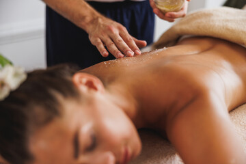 Woman Enjoying Peeling Massage With Salt In Spa Centre