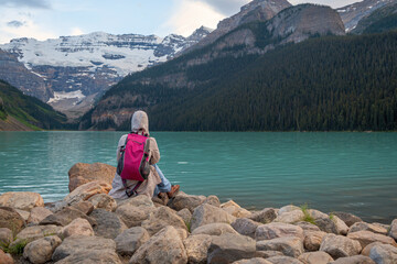 A lady is enjoying lake scenes alone	