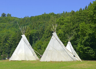 Forest camp and three Indian teepees