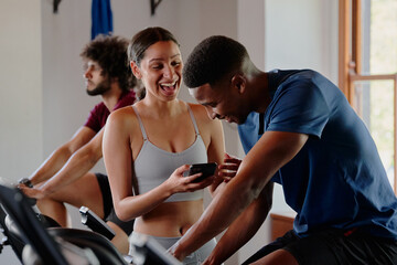 Fototapeta na wymiar Group of young multiracial friends laughing while using mobile phone at the gym