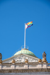 LGBTQ flag flying over the dome of a landmark building in London.
