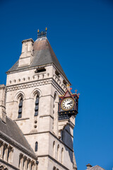 Fototapeta na wymiar A clock hanging from the side of a building on Fleet Street
