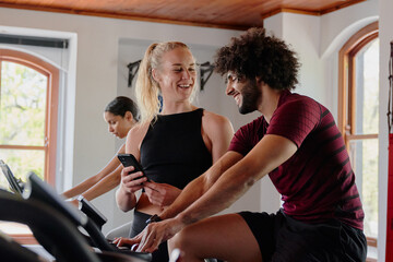 Group of confident young multiracial friends using mobile phone at the gym