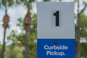 Curbside Pickup Sign in American Parking Lot During the Global Pandemic with the Number One on It - obrazy, fototapety, plakaty