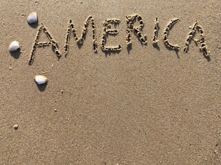 Fototapeta na wymiar on the beach is carved with letters in the smooth sand the writing USA