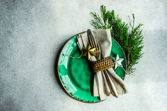 Overhead view of a rustic Christmas place setting with Christmas baubles and thuja branches