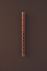 Musical instrument isolated on brown background. Minimal authentic, acoustic flute concept. Simple music art composition. Colorful minimalism.