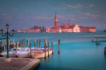 Fototapeta premium Boats docked by wooden mooring poles in grand canal, Ethereal Venice, Italy