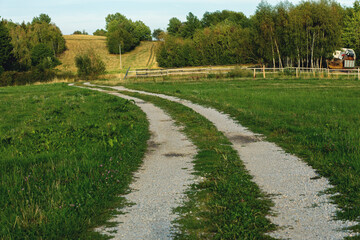 Countryside road crossing the meadow.Summer season.