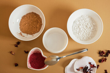 ingredients for making natural face powder. dry hibiscus petal powder, turmeric, starch