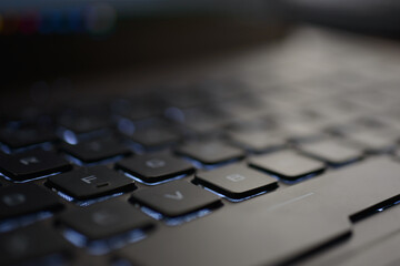 Computer and laptop keyboard details. Black buttons and white color letters on beige and aluminum laptop body