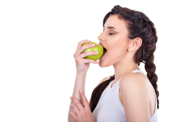 Beautiful young brunette girl eating a green fresh apple isolated on white background