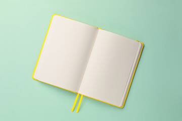 Blank notebook on turquoise background, top view