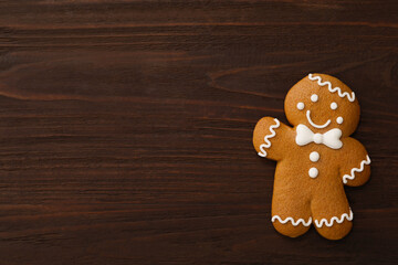 Gingerbread man on wooden table, top view with space for text. Delicious Christmas cookie