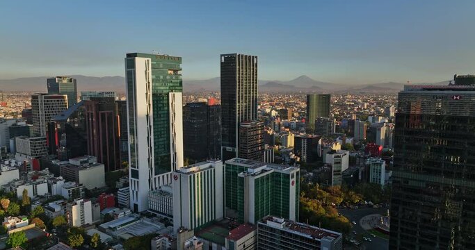 Mexico City Aerial v18 cinematic reverse flyover colonia cuauhtemoc neighbohood capturing fast development of downtown skyscrapers cityscape at sunset - Shot with Mavic 3 Cine - December 2021