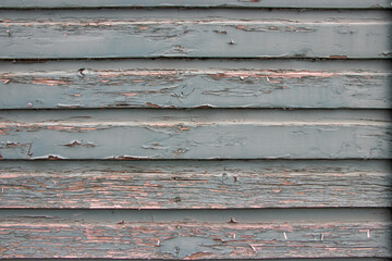close up of paint peeling on wood siding