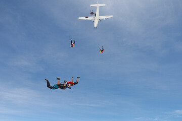 Skydiving. Skydivers are in the sky.