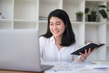 Successful businesswoman holding document and working with computer laptop..