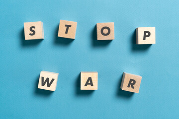 wooden cubes with stop war text on pastel background