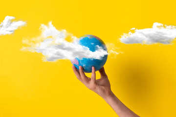 human hands hold planet earth high in the sky with clouds, creative concept