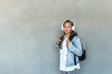 Student life, modern lifestyle and education concept. cheerful pretty female student with headphones and backpack