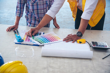 Civil engineer teams meeting working together wear worker helmets hardhat on construction site in modern city. Foreman industry project manager engineer teamwork. Asian industry professional team