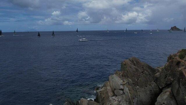 Drone Video Footage of Saint Barthelemy, Gustavia Regatta Sailboats racing in the sea with clear skies and calm waters near the coast with islands around beautiful and scenic 