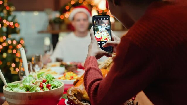 black woman uses a cell phone or smartphone to take pictures of her boyfriend on Christmas day.Happy couple celebrating Thanksgiving and Christmas eve day.