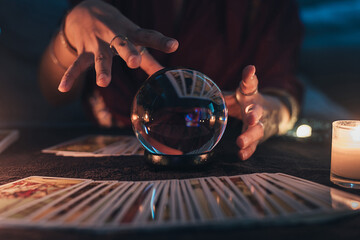 Fortune teller with illuminated crystal ball and tarot cards to prediction future. Hands of astrologists reading future and destiny. Horoscope and forecasting concept. - obrazy, fototapety, plakaty
