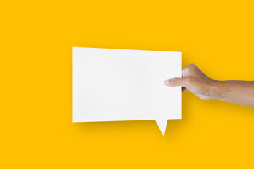 hand holding a square shaped white paper balloons speech bubbles isolated on yellow background communication bubbles