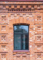 Fototapeta na wymiar The window of the old mansion 19 century with brown bricks wall