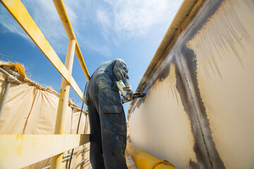 A male worker at high test steel tank butt weld overlay carbon shell plate of storage tank oil