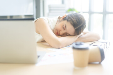 Young adult business asian woman fatique and sleep on table at office