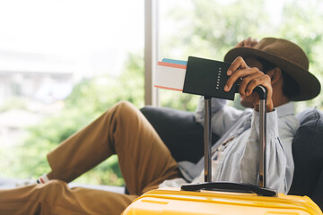 Traveller asian man arm holding luggage handle passport and reservation airplane ticket