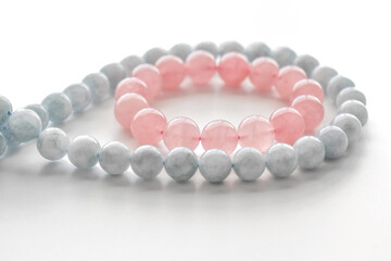 Rose quartz bracelet and aquamarine strand on the table. 