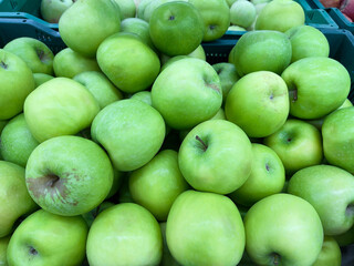 Green apples close-up in a box. The fruit department of the store.