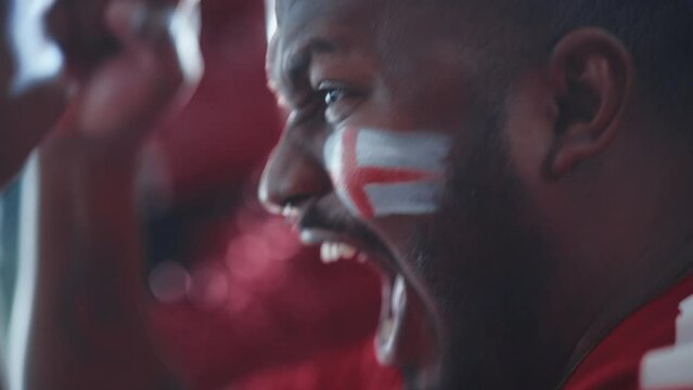 Sport Stadium Sport Event: Close-up Portrait of Handsome Black Man with Painted Cheering for Red Team to Win, Screaming in Celebration of a Victory. International Championship, World Tournament Cup
