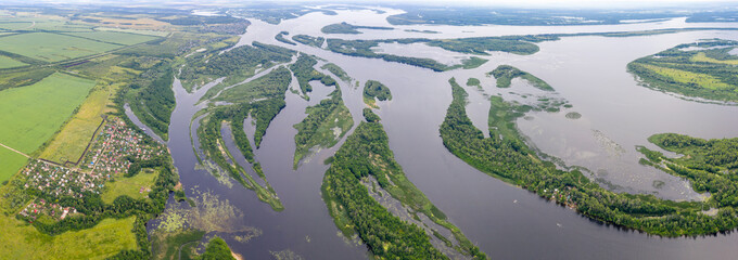 Panoramic aerial view of Volga river and Kommuna village on sunny summer day. Saratov Oblast, Russia.