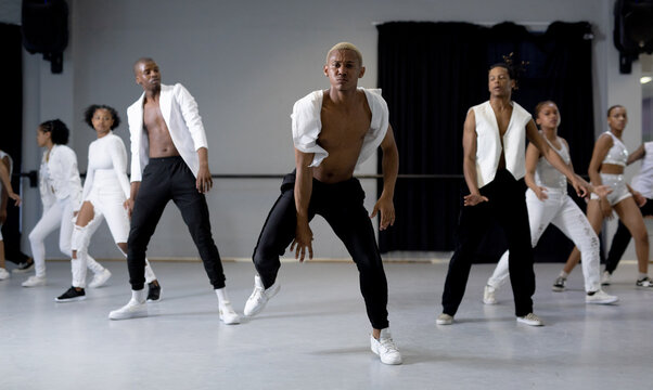Group of modern dancers practicing a dance routine in a studio