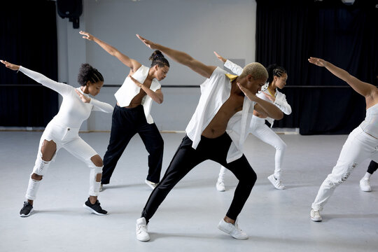 Group of modern dancers practicing a dance routine in a studio