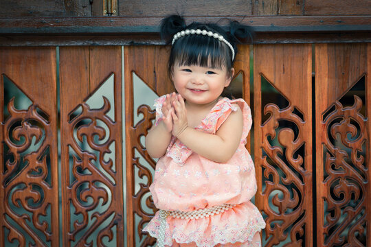 Happy Thai baby do hello or sawasdee in songkran festival. 1 year 6 month baby in a Thai style use as concept of play, songkran, mood and motion of baby and kid development.