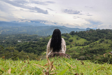woman sitting on a rock contemplating mountain views