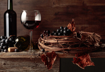 Glass and bottle of red wine on an old wooden table.