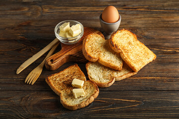 Composition with toasts, butter and egg on wooden background