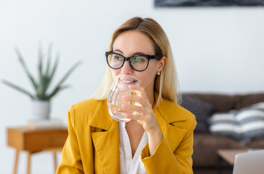 Healthy lifestyle concept. Recuperation concept. Portrait of a beautiful young business woman drinking clean water