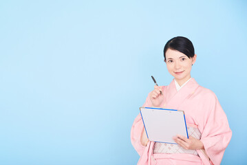 Obraz premium メモを書く着物を着た女性
