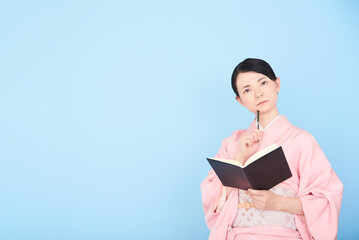 Obraz premium 手帳を書く着物を着た女性