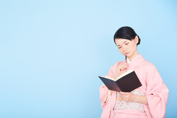 Obraz premium 手帳を書く着物を着た女性