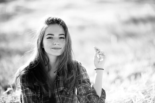 black and white portrait of a cheerful girl country style, freedom young female in a field of straw